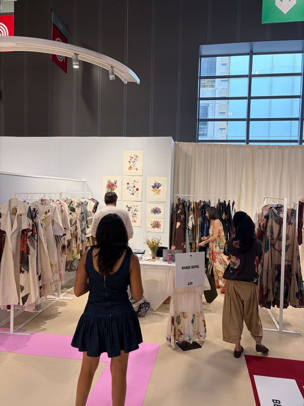 Buyers looking through hand-painted dresses on the Khara Kapas stand, A39, at Who's Next Paris, September 2026.