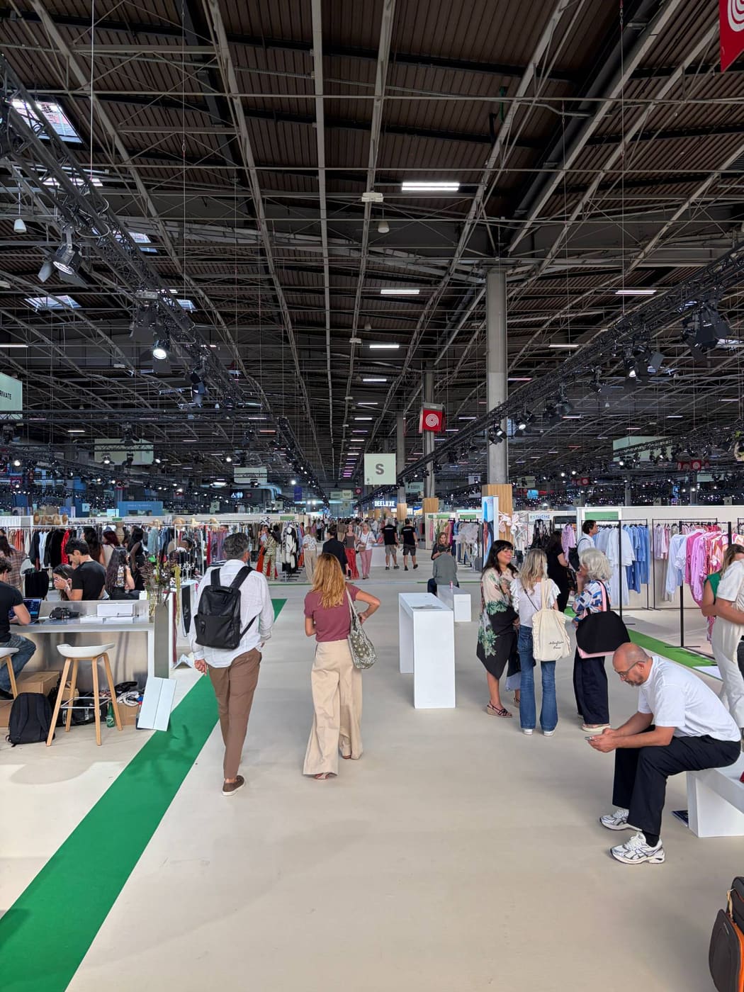 Buyers walking a main aisle of ready-to-wear stands at Who's Next Paris, Porte de Versailles, September 2026.
