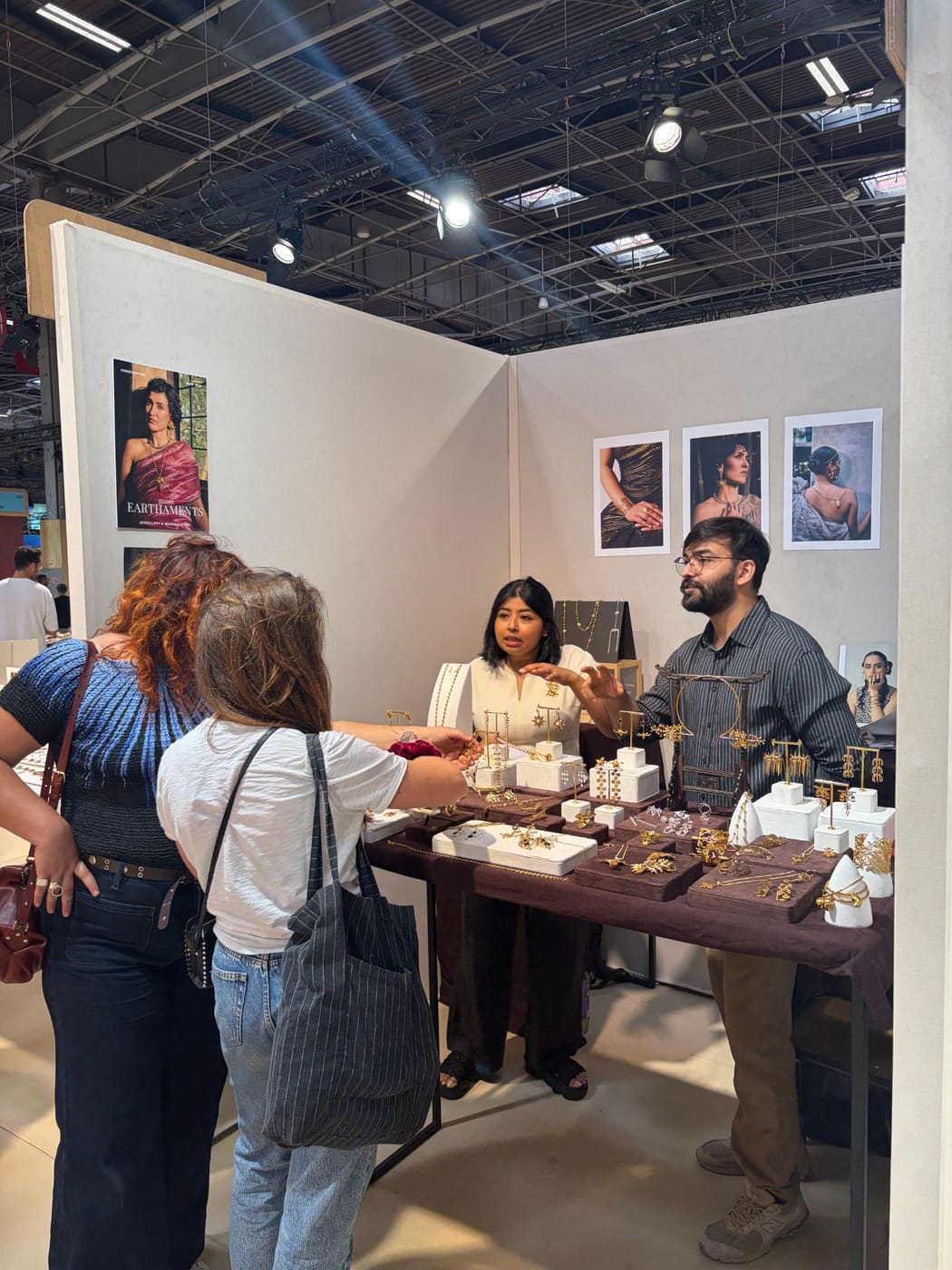 Two buyers looking at gold jewellery with the Earthaments team at their stand at Bijorhca, September 2026.