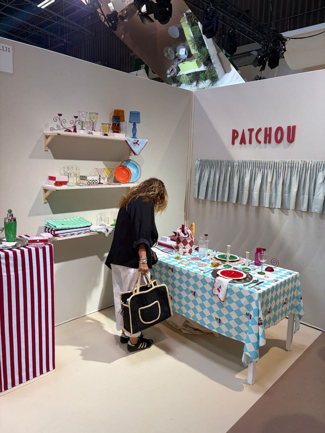 A buyer looking at tableware and printed table linen on the Patchou stand at Shoppe Object Paris, September 2026.