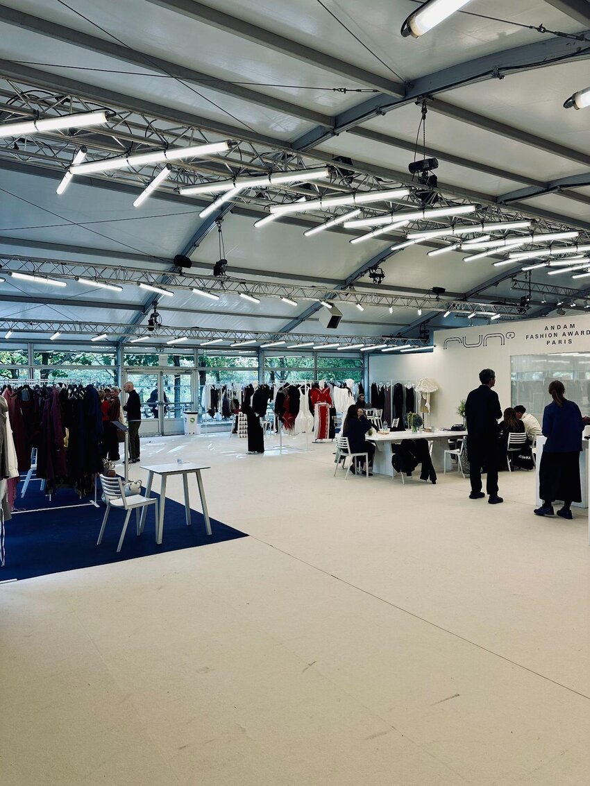 Inside the RUN x ANDAM showroom, with racks and buyer tables under the Tuileries tent.