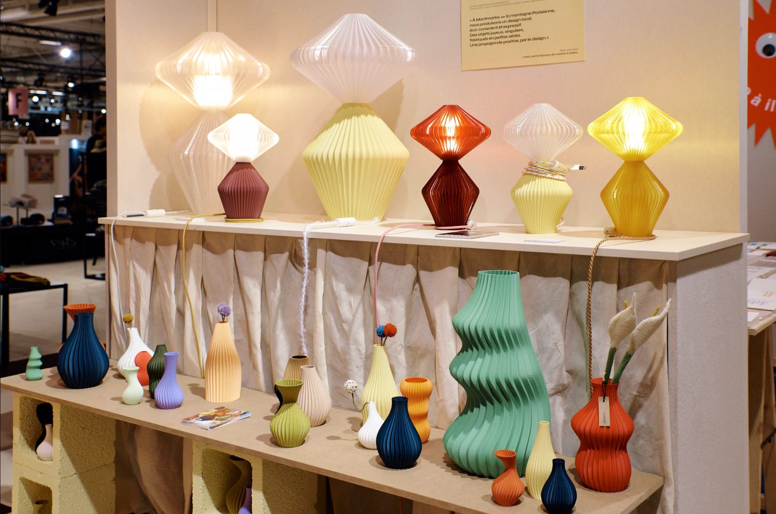 Colourful small-series design lamps and vases on a stand at Shoppe Object Paris.